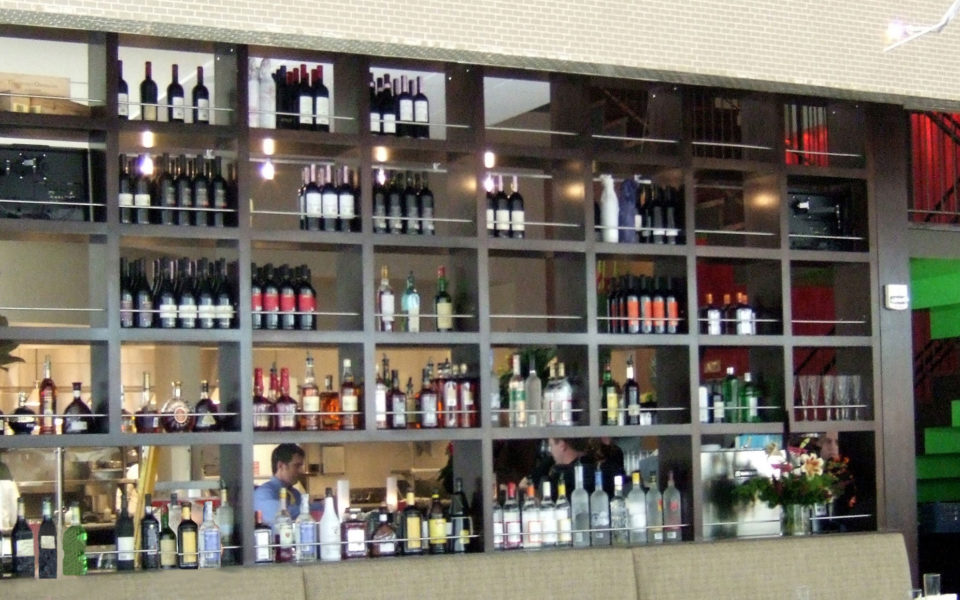 Custom bar, open on both sides, holding large inventory of spirits