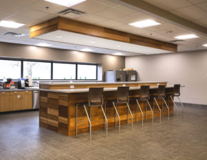 Corporate kitchen with large island featuring wood paneling
