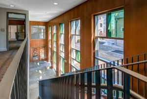 Two-story lobby area with wood paneling along exterior wall