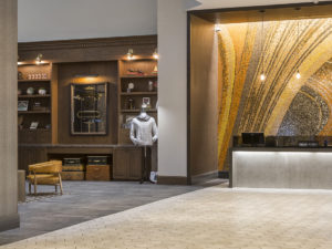 Large hotel lobby with stunning mosaic behind hospitality desk