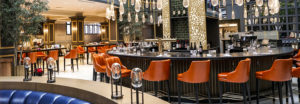 ornate curved bar with orange chairs